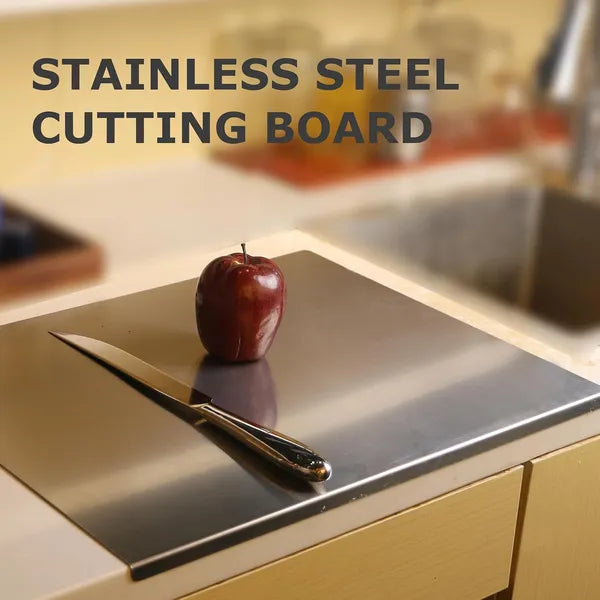 Stainless steel cutting board on kitchen counter with red apple and knife showing sleek modern design
